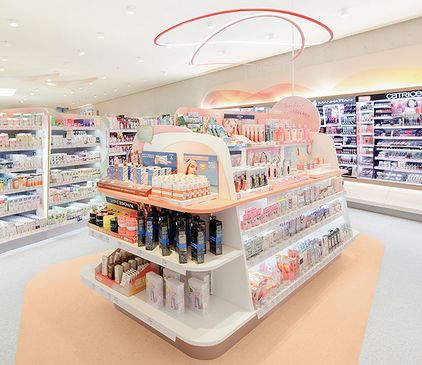 Ein hell erleuchteter, dm-drogerie Markt mit übersichtlich angeordneten Regalen mit Hautpflege- und Schönheitsprodukten in Pastellfarben.