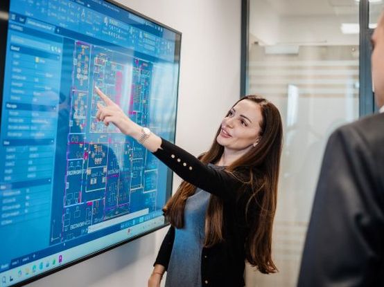 Колежка от отдел експанзия показва нещо на друг колега