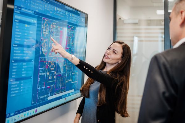 Колежка от отдел експанзия показва нещо на друг колега